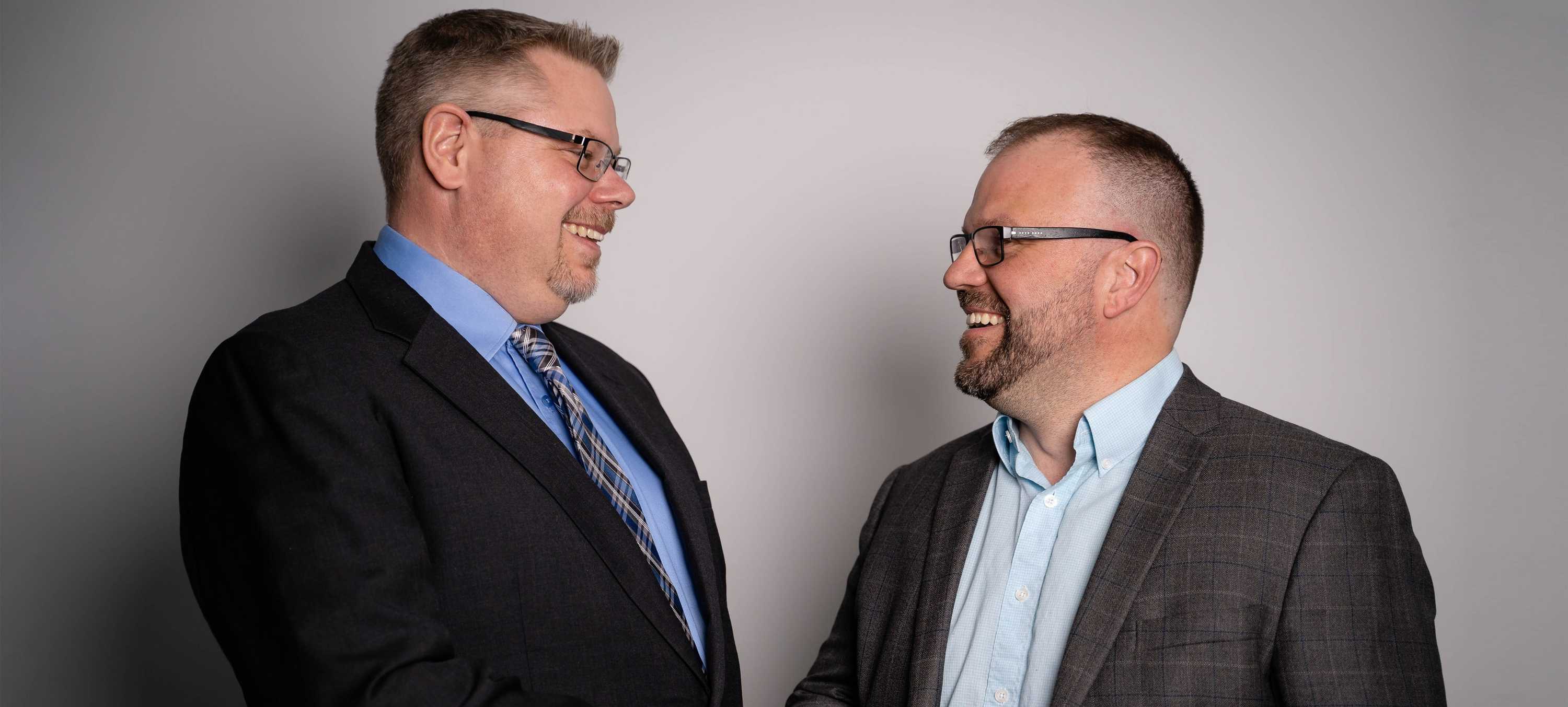 A picture of 2 business men shaking hands inside an office